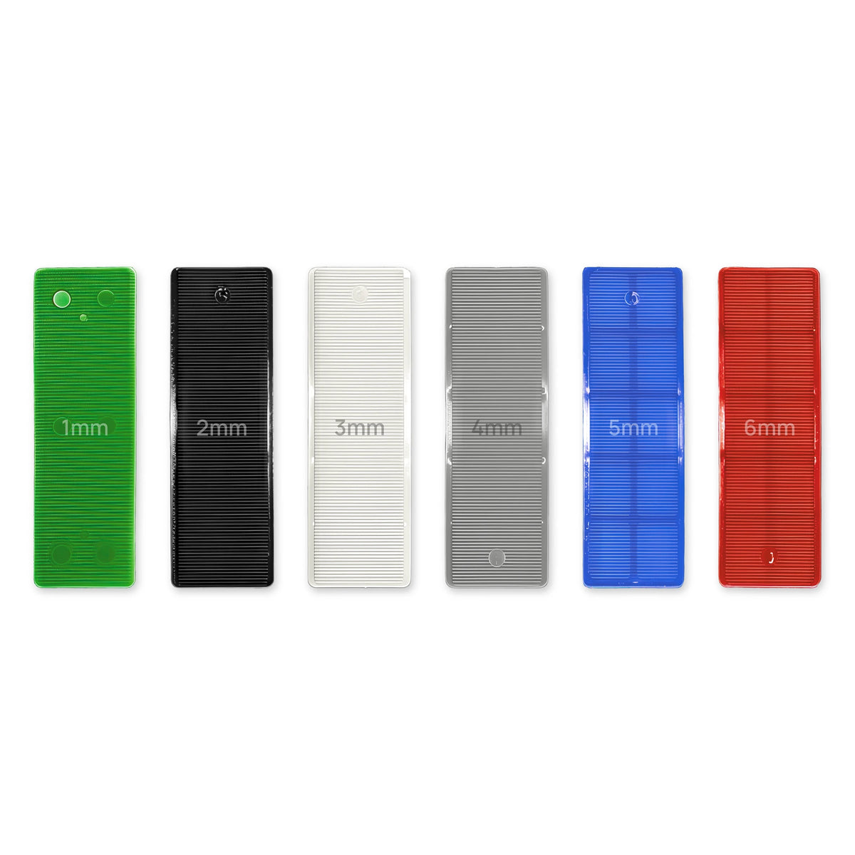 Flat plastic glazing packers, 32mm x 100mm, in six thicknesses from 1mm green to 6mm red.