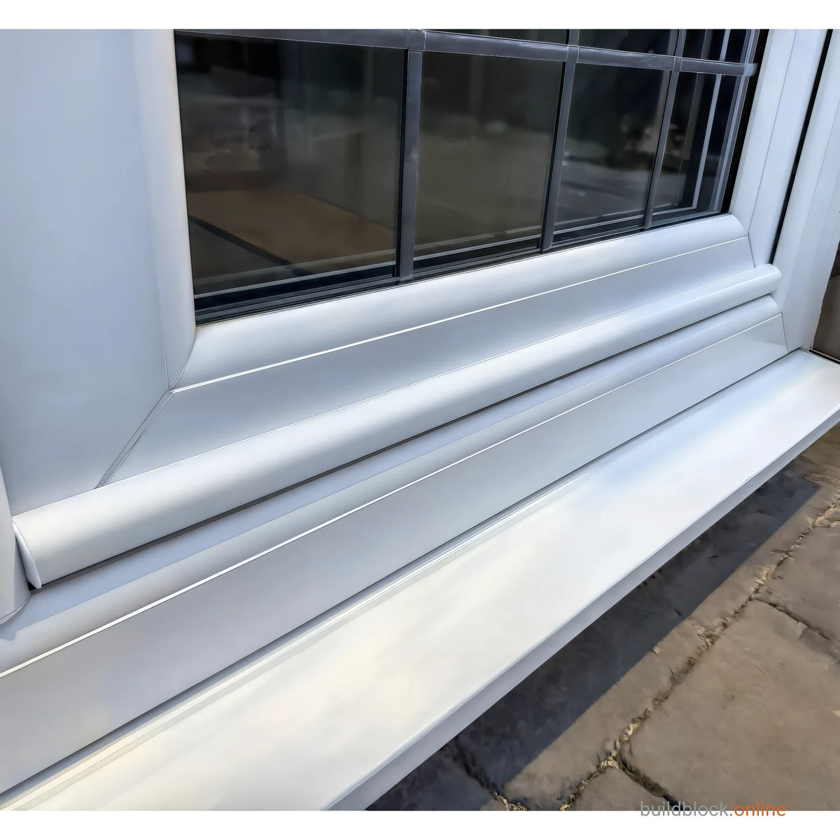 White uPVC weather bar fitted across the foot of a white uPVC door, above the threshold
